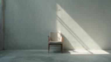 Boş bir odada, gri beton duvarlı bir pencereden içeri güneş ışığı akan tek koltuğun bulanık arkaplanı. Minimalist ve düşünceli bir iç mekan. Poster, duvar kağıdı ve afiş için tasarım. Aktar.