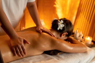 Beyaz kadın müşteri stres önleyici spa masajının keyfini çıkarıyor ve lüks otel ya da otelde sıcak mum ışığında güzellik teniyle eğleniyor. Sessiz.