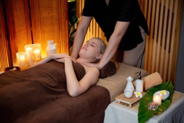 Beyaz kadın müşteri stres önleyici spa masajının keyfini çıkarıyor ve lüks otel ya da otelde sıcak mum ışığında güzellik teniyle eğleniyor. Sessiz.