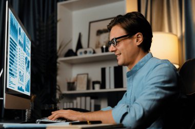 Akıllı iş adamı iş paragrafı dinamik pazarlama analizi planını analiz ediyor. Kağıt kağıtları ve bilgisayar monitörü raporlarını gece evdeki belge verileriyle karşılaştırmak için hazırlıyor. Bireysel.