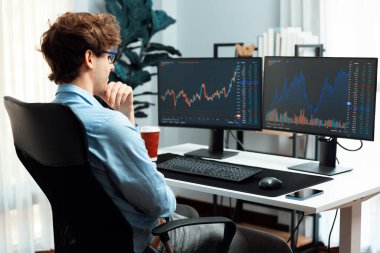 Mevcut pazar grafiğinde dinamik finans yatırımı arayan borsa simsarının genç yatırımcısı, modern ofiste gerçek zamanlı yoğunlaşıyor, istatistiksel karı analiz ediyor. Toplayıcı.