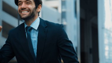 Cam duvarda yürürken neşeyle dans eden yetenekli bir iş adamı. Proje müdürü iyi haberler aldı, terfi aldı, başarılı bir iş buldu, aynı zamanda coşkuyu dile getirdi. Sevinçli..