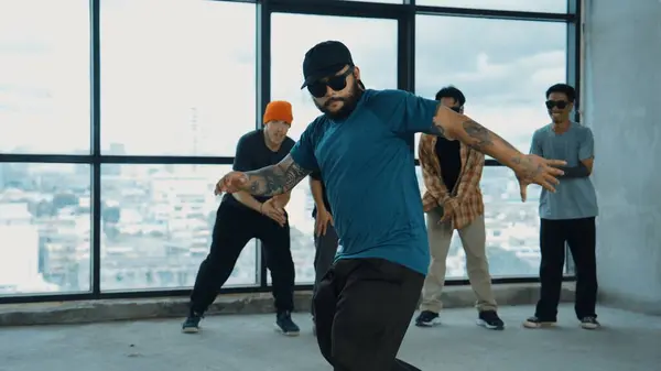 stock image Multicultural hipster group looking at camera while perform break dancing at building with sky scrapper or city view. Street dancer team looking at dancer performance. Outdoor sport 2024. Endeavor.