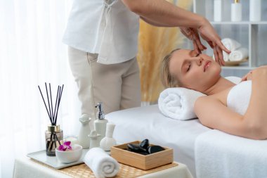 Kafkasyalı kadın stres önleyici kafa masajından ve lüks tatil beldesi ya da otel spa salonundaki modern ışık ortamında yüz güzelliği eğlencelerini şımartmaktan hoşlanıyor. Sessiz.