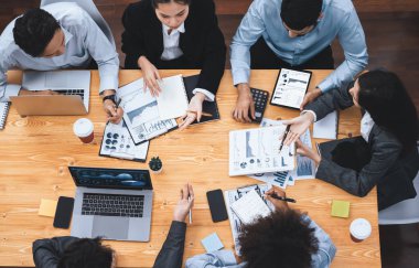 Çok ırklı analist ekibi toplantıdaki finansal verileri analiz etmek için BI Fintech yazılımı kullanıyor. Üst görünüm finans paneli veri ekranında pazarlama göstergesi için analiz edilmiş grafikle birlikte. Uyum