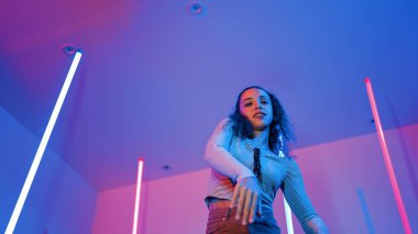 Latin dansçıların kameraya bakıp şehrin pop müziğiyle dans ettiği düşük açılı kamera. Profesyonel çekici hipster, mor veya neon ışıklı hip hop şarkısına geçiyor. Şık bir kumaş. Mutluluk.