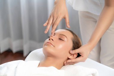 Kafkasyalı kadın stres önleyici kafa masajından ve lüks tatil beldesi ya da otel spa salonundaki modern ışık ortamında yüz güzelliği eğlencelerini şımartmaktan hoşlanıyor. Sessiz.