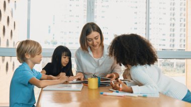 Masada masal kitabı ve renkli kitapla otururken çeşitli öğrencilere hikaye anlatan profesyonel beyaz bir öğretmen. Eğitmenden renkli resim alırken akıllı öğrenci dinlemeyi öğrenir. Etkinlik.