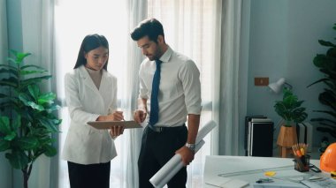 Yetenekli mimar mühendis ekibinin planlara birlikte baktığı en iyi manzara. Birlikte çalışırken tablet tutan akıllı tasarımcıların hava görüntüsü ve yapı hakkında beyin fırtınası. Hizalama.