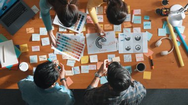 Ekiple tartışırken, yetenekli tasarımcı logosunun yukarıdan görünüşü. Hava ticareti grubu logo grafik tasarımı hakkındaki fikri yapışkan notlar ve tablet kullanarak paylaşıyor. Sempozyum.