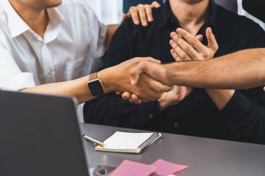 Çeşitli ofis çalışanları stratejik iş pazarlama toplantısı üzerine anlaşma yaptıktan sonra el sıkışıyor. Takım çalışması ve olumlu tutum verimli ve destekleyici bir iş yeri yaratır. Tedbirli
