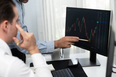 En yüksek borsayı işaret eden borsacı gerçek zamanlı izleme ekranı üzerinde dinamik değerli analiz araştırması yapan iş arkadaşını tanıtıyor. Finans şirketlerinin borsasında iş birliği yapıyor. Satılabilir.