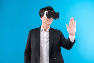 Asyalı işadamı, sanal gerçeklik mavi telif uzayı yenilik teknolojisini analiz eden gelecekçi metaevrendeki iş dünyası raporuna dokunarak ekranı titizlikle inceliyor. Entrika.