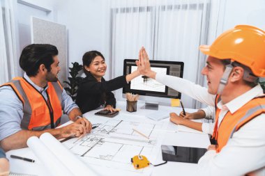 Çeşitli inşaat mühendisi ve müvekkil grupları, mimari proje üzerinde başarılı bir anlaşma yaptıktan, inşaat planını gözden geçirdikten ve toplantı masasında plan oluşturduktan sonra kutlama ve beşlik çakışma yaptılar.