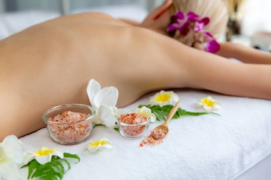 Lüks spa salonlarında sıcak mum ışığında cilt bakımı yaptıran kadın müşteri. Sağlık Spa vücut fırçasında tuz temizleme güzellik tedavisi. Sessiz.