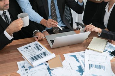 Ofis masasındaki finansal veri raporlarını analiz eden çeşitli bir grup iş analisti. Stratejik pazarlama planlaması için iş istihbarat analizine göre grafikler ve grafikler.