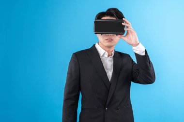 Sanal gerçeklikteki yenilik teknolojisi reklamlarını analiz ederek iş dünyası raporuna tam anlamıyla bağlanan gülümseyen Asyalı işadamı. Entrika.