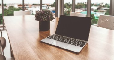 Ofis çalışma alanındaki masada açık kapaklı dizüstü bilgisayar. uds