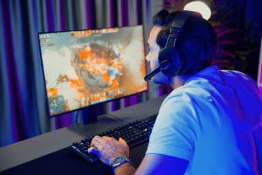 Moba çevrimiçi oyununa odaklanan akıllı akım oyunculu kulaklıklar takarak bilgisayar ekranında mupti ya da neon dijital siber ışık odasındaki savaş alanında yetenekli bir takım ile birlikte. Tahmin et..