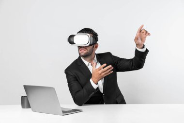 Bilgisayarla masada otururken ve VR gözlüğü takarken veri analizine bakan yetenekli bir iş adamı. Proje yöneticisi sanal gerçeklik sistemini kullanarak ya da metaevrende bağlantı kurarak çalışıyor. Sapma.