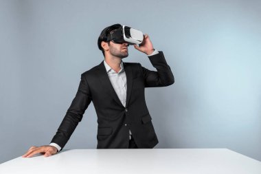 İş adamı, sanal gerçeklik gözlüğü kullanırken finansal plan yapıyor. Profesyonel proje yöneticisi metaevreni bağlamak için görsel gerçeklik gözlüğü kullanırken pazarlama stratejisi arıyor ve düşünüyor. Sapma.