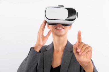 Profesyonel kadın lider programa dokunuyor ya da sanal gerçeklik gözlüğü kullanırken çalışıyor. Yetenekli iş kadını, görsel gerçeklik gözlüğü takarak metaevrene bağlanırken sistemi işaret ediyor. Kısıtlanma.