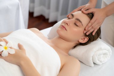 Kafkasyalı kadın stres önleyici kafa masajından ve lüks tatil beldesi ya da otel spa salonundaki modern ışık ortamında yüz güzelliği eğlencelerini şımartmaktan hoşlanıyor. Sessiz.