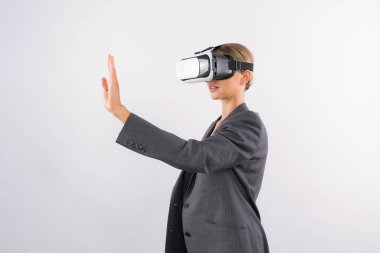 Akıllı iş kadını bir şeye dokunurken VR camına bakar. Takım elbise giyen yetenekli proje yöneticisi ve metaevrene bağlanmak için görsel gerçeklik gözlükleri takıyor. Kısıtlanma.