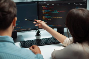 İki ekran ekranında yaratıcı web sitesi planlama yazılımını tartışan yetenekli geliştiriciler programı arka görüş konseptiyle ofiste tasarımı analiz eden tam yığın veri. Varsayım.