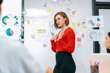 Profesyonel çekici kadın lider, modern iş toplantı odasında beyin fırtınası zihin haritalama istatistikleri ve renkli yapışkan notlar kullanarak yaratıcı pazarlama planını sunuyor. Tertemiz..