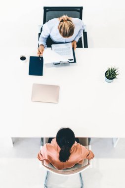 İş başvurusu ve iş anlaşması için ofis masasında toplanan iki genç iş kadını. İşe alım ve insan kaynakları kavramı. uds