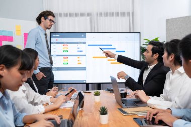 Proje yöneticisi toplantı odasında iş programları, Gantt program programı TV ekranında. Çoklu etnik çeşitlilik iş adamları ve modern iş projesi yönetimi. Habiliment