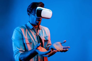 Şaşkın adam neon ışığı altında sanal gerçeklik gözlüğü kullanırken bekliyor. Yenilik teknolojisi kullanarak simülatör programına girmek için sanal gerçeklik gözlüğü takan beyaz bir insan. Sapma.