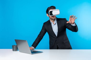 Akıllı iş adamı teknoloji yeniliklerini kullanarak veri analizini seçerken dizüstü bilgisayarla masada duruyor. Sanal gerçeklik gözlüğü ve sanal gerçeklik gözlüğü kullanan yetenekli Kafkas proje yöneticisi. Sapma.