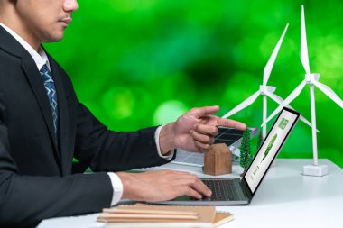 Ofiste çalışan iş adamı, CSR 'ın dışında daha yeşil bir çevre için bilgisayar ekranında güneş pili teknolojisiyle çevre dostu alternatif enerji planı veya projesi geliştiriyor. Döngü