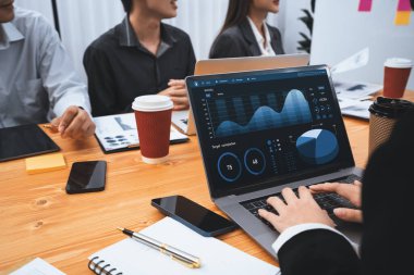 Çok ırklı analist ekibi toplantı masasındaki finansal verileri analiz etmek için BI Fintech yazılımı kullanıyor. Finansal konsol veri ekranında pazarlama göstergesi için analiz edilmiş grafikle birlikte. Uyum