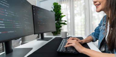 İnternet sitesi uygulamasının kodlama verileriyle birlikte online bilgi yazarak kot gömlek giyen genç Asyalı geliştirici. Güvenlik analizi ile çevrili iki ekran. Taktik.