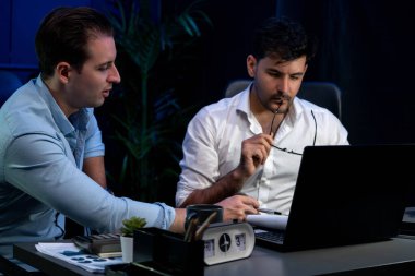 İş ortaklarının veritabanı pazar bilgi analizini dizüstü bilgisayarda tartışmalarına destek olmak, pazarlama stratejisini çevrimiçi analiz etmek için yeni bir proje düşünürken gözlük takan bir adam. Satılabilir.