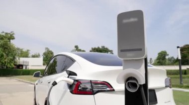 Green City Park 'taki otoparkta yavaş çekim EV elektrikli araba şarj bataryası. Sürdürülebilir ve çevre dostu şehir yolculuğu için yenilenebilir otomobil için alternatif temiz enerji teknolojisi. Yararlı