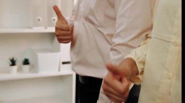 Panoramik video mutlu Asyalı şirket çalışanı renkli günlük kıyafet giyer yan yana durur yaratıcı takım çalışmasını, iş istihdamını, HR ajansını sembolize eden başparmağını kaldırır. Sinerjik