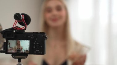Güzellik ve kozmetik öğretim videosu içeriği yapan kamera görüntüsü kadını ya da perde arkası görüntüsü. Güzellik blogcusu izleyicilere ya da sosyal medya takipçilerine güzellik hizmetinin nasıl uygulanacağını gösteriyor. Blithe