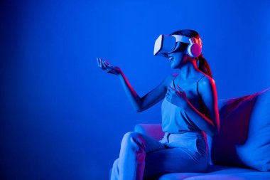 Kanepede oturan zeki kadın, neon ışıklı kulaklık takıyor metazik, fütüristik siber uzay topluluğu teknolojisini birbirine bağlıyor, elle sanal nesneyi izliyor ve onunla etkileşime geçiyor. Halüsinasyon.