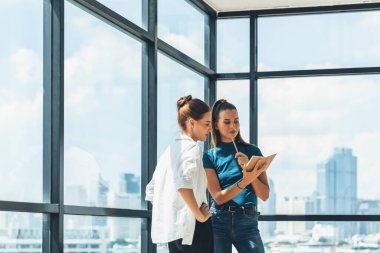 Genç, güzel, profesyonel mimar mühendis takımının portresi ev tasarımı hakkında konuşuyor. Yetenekli iş kadını beyin fırtınası yapıyor ve gökdelenle çevrili pazarlama fikirlerini paylaşıyor. İzleme.