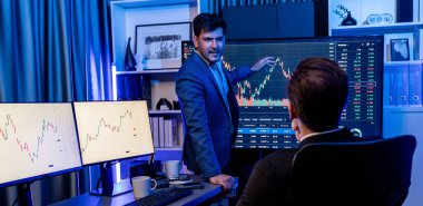 İki borsa simsarı, Panorama 'da gece gözlemde dinamik değerli yatırım oranını tartışıyor. Borsadaki işadamı işyerinde neon ışıkta ekonomiyi sunuyor. Satılabilir.