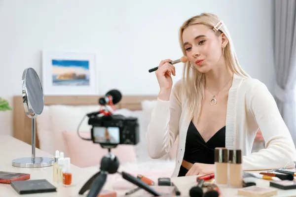 stock image Young woman making beauty and cosmetic tutorial video content for social media. Beauty blogger smiles to camera while showing how to beauty care to audience or followers. Blithe