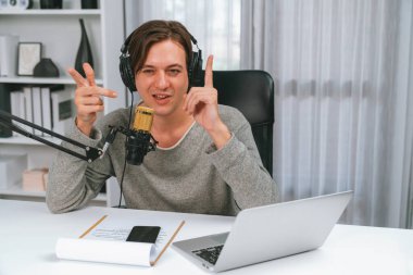 Sunucu kanalı, gülümseyen akıllı yayıncı kaydı, senaryosu ve akıllı telefonuyla sosyal medyada sohbet programı, kulaklık takarak modern ev stüdyosundaki video flamalarını kaydediyor. Bireysel.