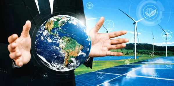 stock image Concept of sustainability development by alternative energy. Man hand take care of planet earth with environmentally friendly wind turbine farm and green renewable energy in background. uds