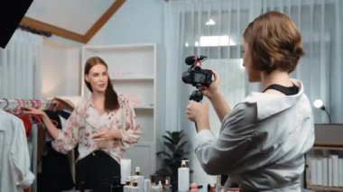 İki kadın nüfuzlu kişi canlı yayın yapan video klip eleştirisi kıyafetlerini sosyal medyada ya da blogda yayınlıyor. Stüdyo ışıklandırmalı mutlu genç kız çevrimiçi pazarlama oturumu yayını için..