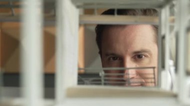 Kafkasyalı mimar mühendisinin yakın çekimi ev inşaatını denetlemek ve bina malzemelerini kontrol etmek. Proje yöneticisi modele dikkatlice bakarken kalemi işaret ediyor. Yönlendirici.