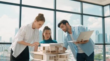 Akıllı mimar takımı ev tasarımı hakkında tartışırken yakışıklı erkek işçi dizüstü bilgisayar kullanarak fikir sunuyor. Profesyonel mühendis paylaşımı, beyin fırtınası tasarımı. İş tasarımı. İzleme